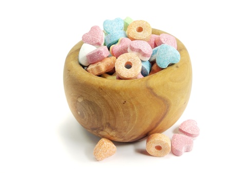 colorful chewy dragees in wooden bowl on a white background 
の写真素材