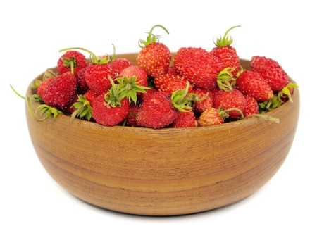 Red wild strawberry in wooden bowl on a white background 
   の写真素材