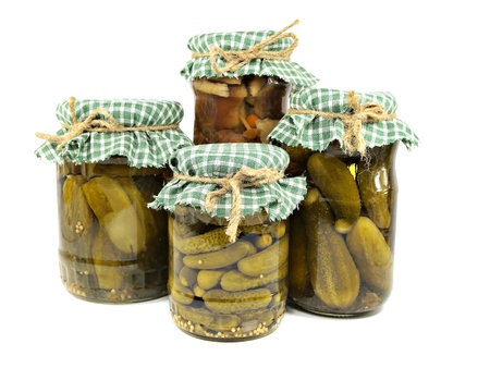 Glass jars of preserved mushrooms and pickles on a white backgroundの写真素材