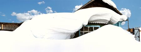 Winter in Siberia. The house is completely covered with snow in a Siberian village.の写真素材