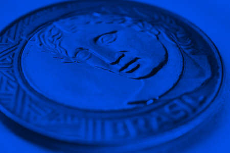 Brazilian 1 real coin close up. Figure of the Republic, the national symbol of Brazil. Dark blue...