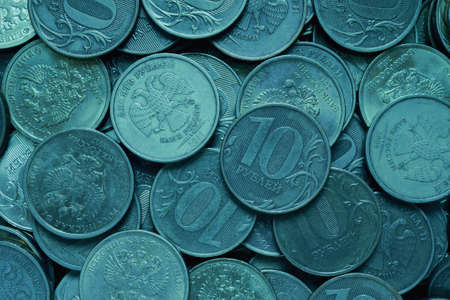 A surface of Russian coins of 10 rubles. Dark turquoise tinted background. Economy and the Central Bank of Russia. money textured wallpaper. ruble backdrop. close-upの写真素材