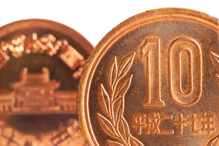 Japanese ten yen coins on both sides stand on a white background. Fragments of close-ups. not isolated. Picture with high contrast, sharpness and saturation. Shot with a macro lensの写真素材