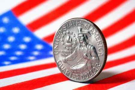 US quarter dollar coin with drummer close-up and USA flag. Stars and stripes in the blur. A vivid illustration of American patriotism and Independence Day July 4. Macroの写真素材