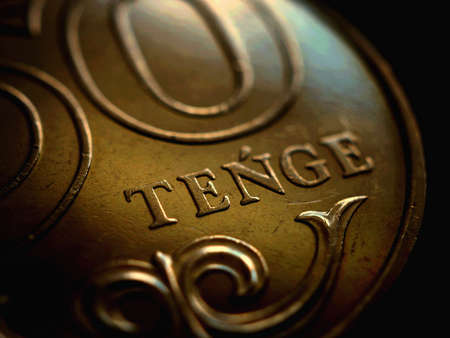 Translation: tenge. Fragment of Kazakh coin in 50 tenge. The name of the currency in Latin. Dark...