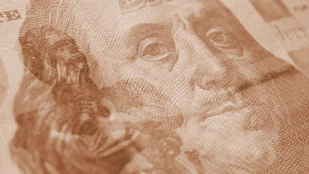 Fragments of Russian and American paper money close-up. ruble and dollar. A banknote of 5000 rubles and a note of 100 dollars. Light brown tinted background about exchange rate. News of economy. Macroの写真素材