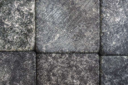 Stone cobblestones, background close-up. natural texture. Dark gray backdrop or wallpaper. Rough surface. Aged effect shot. reduced contrast. Macroの写真素材