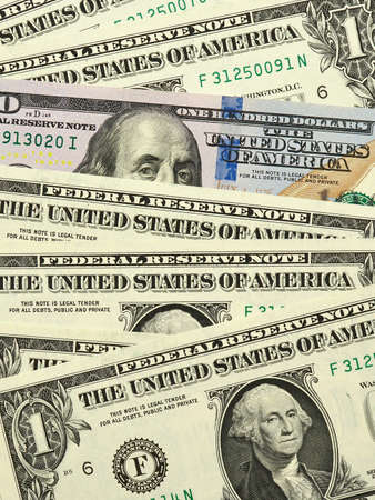 american money close up. A colored 100 dollar bill peeks out of a row of 1 dollar bills. Vertical...