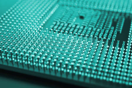 computer processor close up. Turquoise tinted background or backdrop. information technology wallpaper. A pattern of contacts and semiconductors of a pc microprocessor. Macroの写真素材