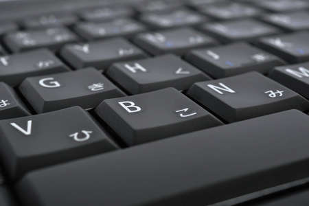 Japanese typing. Black laptop keyboard. Symbols on the buttons of hiragana. Electronic commerce in Japan. IT technologies and data storage. Dark computer background or wallpaperの写真素材
