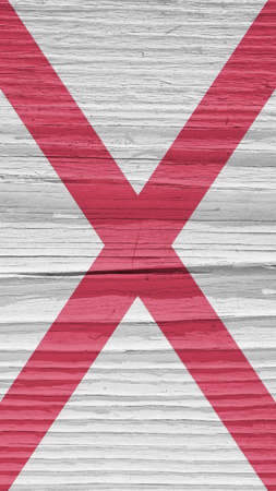 Alabama state flag on dry wooden surface. Light, pale, faded paints. vertical mobile phone wallpaper. Background made of old wood with the symbol of one of the American states. hard shadowsの写真素材