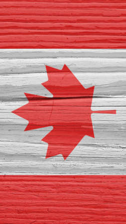 Fragment of Canadian flag on a dry wooden surface. natural vertical background. Mobile phone wallpaper made of old wood. The official symbol of Canada. Solar lighting with hard shadowsの写真素材