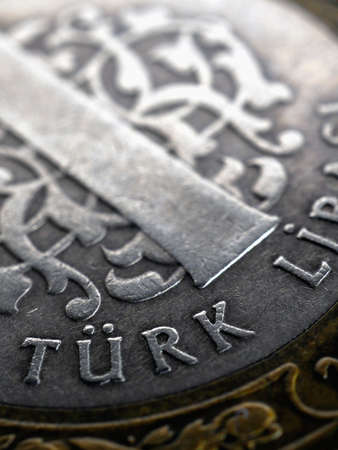 Translation: Turkish lira. Fragment of Turkish 1 lira coin closeup. National currency of Turkey. Vertical illustration for news about economy or finance. Macroの写真素材