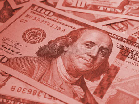 american paper money. A $100 bill with focus on eyes of Benjamin Franklin. US banknotes close-up. Savings economy and the USA dollar. Dark brown tinted background. Macroの写真素材