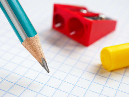 Illustration for the beginning of the new school year. Pencil, sharpener and felt-tip pen close-up on the background of a squared notebook sheet. September 1. Study and education. Macroの写真素材