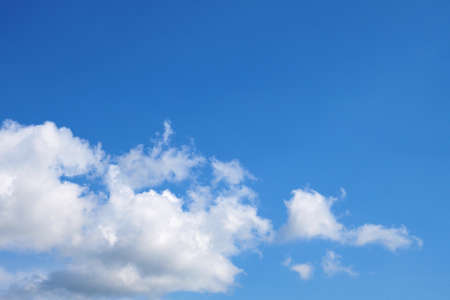 Blue sky and white air clouds. Copyspace background or wallpaper. Right place for text. Summer atmosphere, clear skies. Backdrop for weather forecastの写真素材