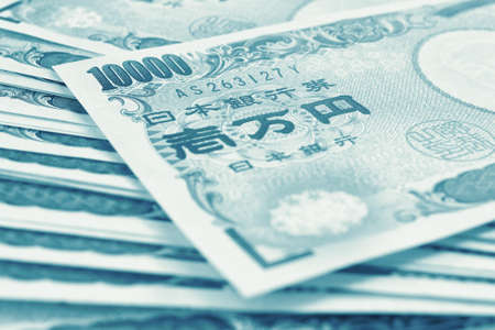 Light background on the theme of Japanese money, finance and economy. Blue green tinted backdrop. Yen banknotes close up. Blurred with focus on 10,000. Banking, savings, deposits and loans. Macroの写真素材