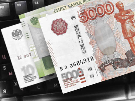 Russian money above the black computer keyboard. Remote job and freelance in Russia. Banknote of 5000 rubles and others. Macroの写真素材