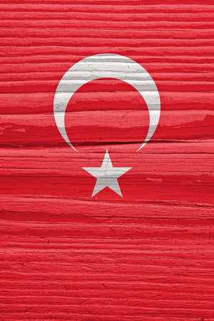 Turkish Flag on a dry wooden surface. Natural background made of old wood. vertical backdrop. The official symbol of Turkey. Solar lighting with hard shadowsの写真素材