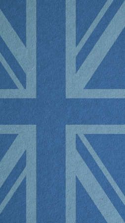 British flag outline on blue cardboard surface. Paper texture with cellulose fibers. mobile phone wallpaper. vertical paperboard background. Symbol of the Great Britainの写真素材