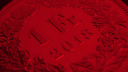1 Swiss Franc coin closeup. Dark red background or wallpaper about economy, business or banking. Money and Central Bank in Switzerland. Macroの写真素材