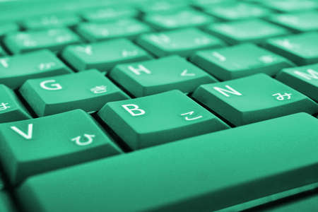 Japanese typing. Light green laptop keyboard close-up. Symbols on the buttons of hiragana. Electronic commerce in Japan. IT technologies and data storage. Bright tinted computer backgroundの写真素材