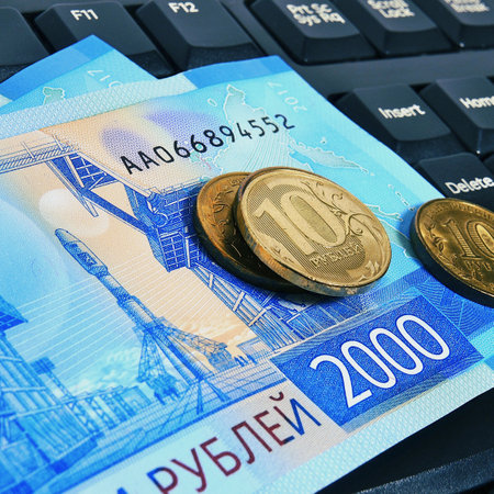 Russian banknotes and coins on the computer keyboard. Remote work, freelance in Russiaの写真素材