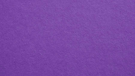 The surface of violet cardboard. Paper texture with cellulose fibers. Dark summer paperboard wallpaper. Bright purple tinted background. Saturated color. top-down. Macroの写真素材