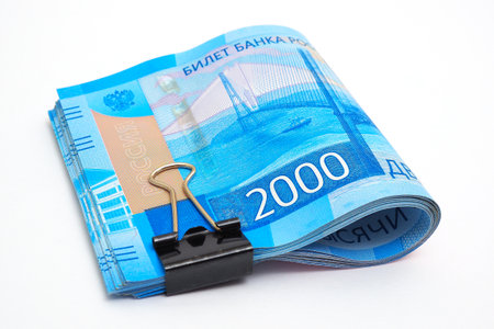 A rolled up bundle of Russian banknotes of 2000 rubles lies on a white paper background. not isolated. Microcredit and microfinance organizations. consumer loans and deposits. Macroの写真素材