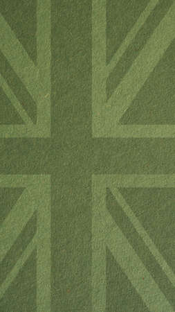 British flag outline on green cardboard surface. Paper texture with cellulose fibers. mobile phone wallpaper. Dark olive paperboard backdrop. vertical background. Symbol of the Great Britainの写真素材