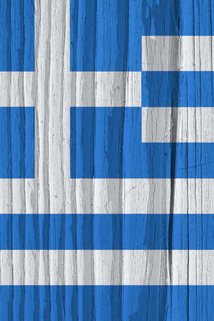 Fragment of flag of Greece on dry wooden surface, cracked with age. Vertical background or wallpaper with Greek national symbol. It seems to flutter in the wind. Hard sunlight with shadows on old woodの写真素材