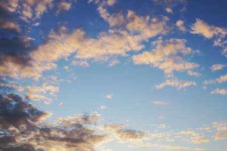 Blue sky, light and dark clouds at sunset. Cloudscape background or wallpaper. end of a sunny summer dayの写真素材