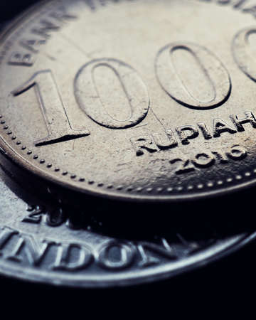 1000 Indonesian rupiah. Fragment of textured coin. Dark dramatic vertical stories about economy or...