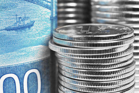 A fragment of a Russian banknote of 2000 rubles depicting a floating ship and a stack of coins....