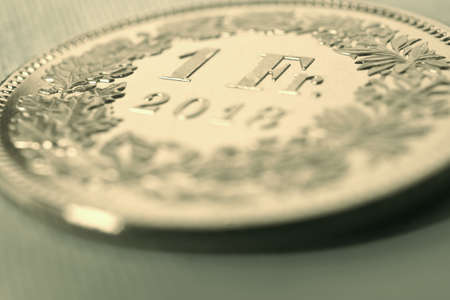 1 Swiss Franc coin close-up. Light yellow background or wallpaper on an economic, business, entrepreneurial or financial theme. Money, Central Bank, banking in Switzerland. Sepia. Macroの写真素材