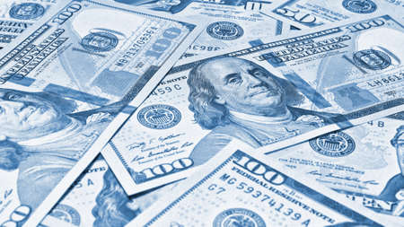 american paper money. 100 dollar and other US notes. Light blue tinted wallpaper or background. Savings economy and the USA dollar. National debt and Treasuryの写真素材