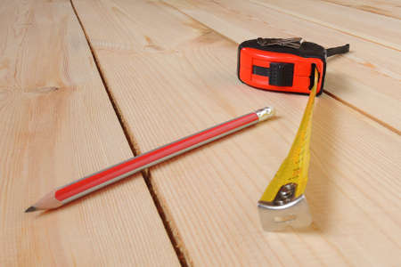Construction tape measure and pencil lie on planned boardsの写真素材