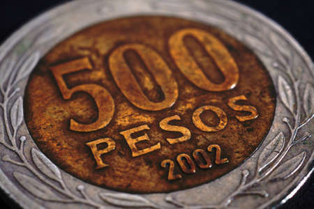 Translation: 500 pesos. Coin of 500 Chilean pesos close-up. Peso of Chile. News about economy or banking. Loan and credit. Money and taxes. Macroの写真素材