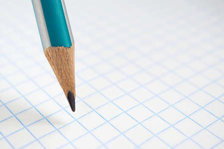 Background on the theme of the new school year with place for text. Pencil and squared notebook sheet close-up. White backdrop for September 1 with copy-space. Macroの写真素材