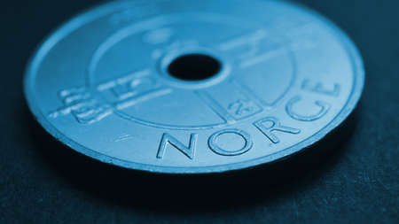 Translation: Norway. 1 Norwegian krone coin closeup. National currency of Norway. Blue tinted money wallpaper about economy or finance. bank and loans. Savings and interest. Kroner and Norges Bankの写真素材