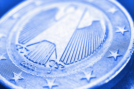 1 euro coin issued in Germany close-up. Obverse with the Federal Eagle. Light blue tinted economic background or backdrop. European Union currency, financial and economic news. Macroの素材 [FY310188669017]