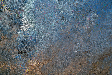 Abstract grainy background in blue and brown colors. Surface of ice crystals close up. Tinted dark...