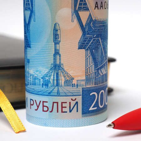 Black daily planner, red pen and a banknote 2000 rubles. Banknote folded into a tube and stands...