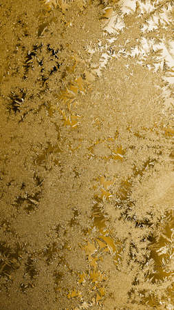 Brown vertical winter background. Tinted translucent wallpaper for mobile phone. Ice crystals close up on a window glass. Bright luxurious and beautiful backdrop for New Year. frozen waterの写真素材