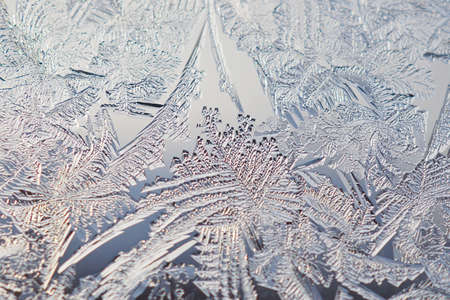 Ice pattern on a window pane in winter. Spectacular crystals of frozen water. It looks like a...