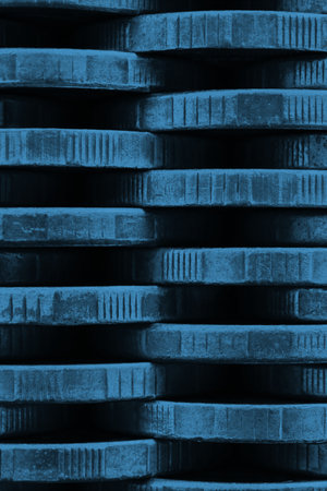 stack of coins close up. coin texture. Blue tinted vertical background made of many coin edges. Economy finance and bank wallpaper. Abstract money wall. Taxes, credit and currency exchange. Macroの写真素材