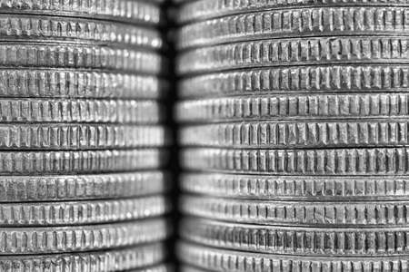 Stacks of US American coins of 25 cents quarters closeup. Black and white background or wallpaper about economy finance banks in the USA. Old money from circulation. Macroの写真素材
