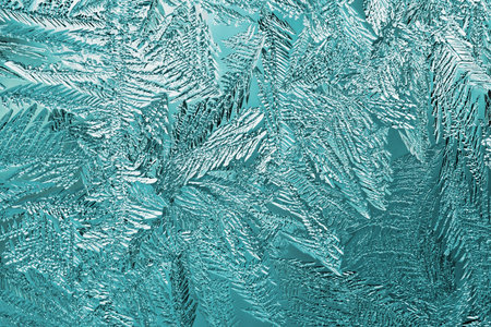 Abstract christmas background. Ice crystals on frozen window glass. frost drawing. A pattern of...