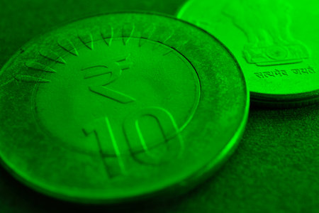 Translation: Truth Alone Triumphs. Two Indian coins lie on textured surface. 10 rupee coin with the sign of national currency. India green tinted backdrop about economy, banking and money. Macroの写真素材