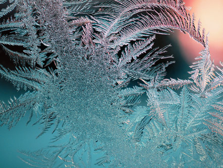 Abstract christmas background. Ice crystals on frozen window glass. Frost drawing. winter season theme. Dark turquoise and red tinted backdrop. Frostwork and frosting pattern. cold and crystal. Macroの写真素材